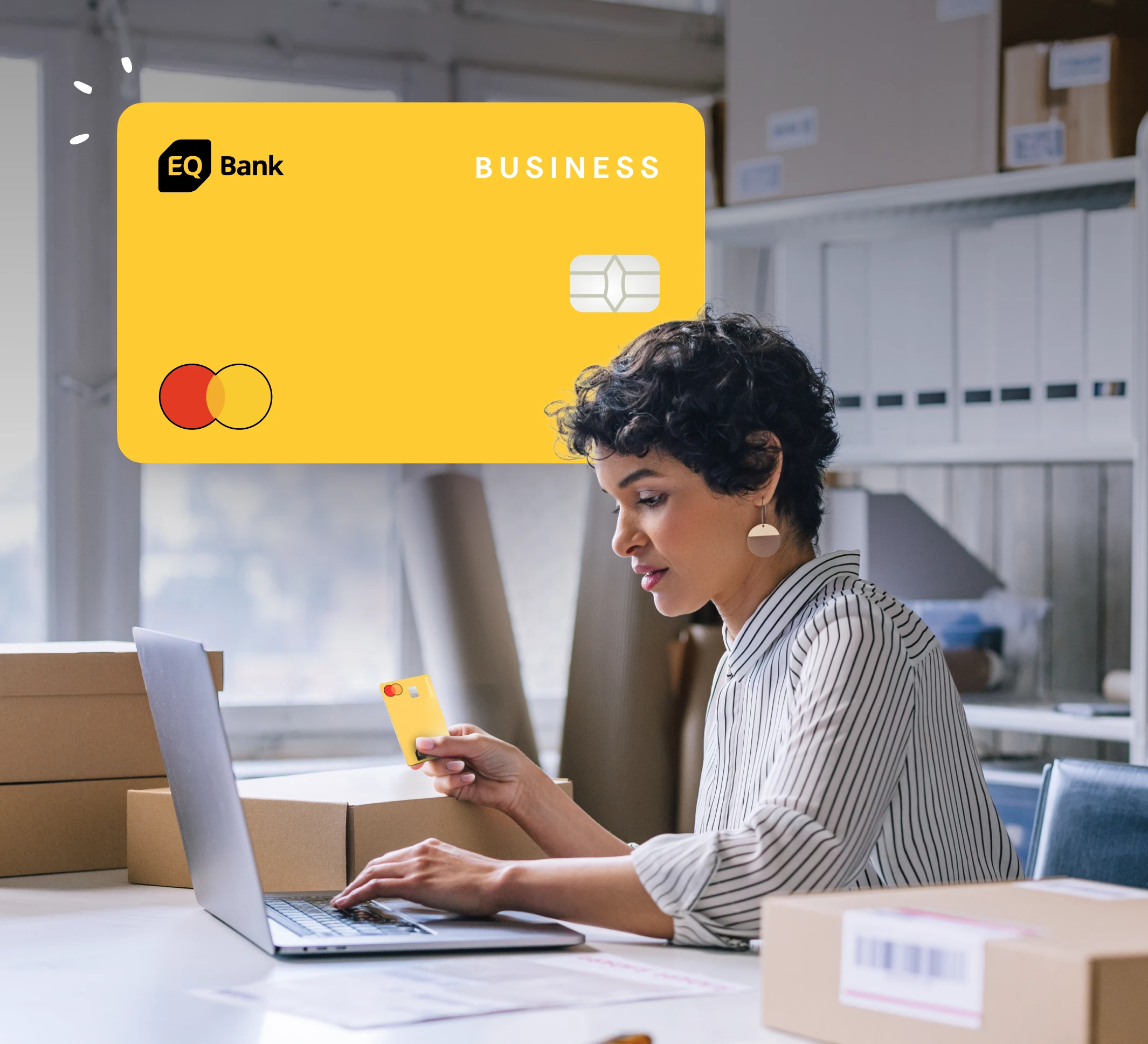 A photograph of a woman in a personal office sitting at a laptop with an EQ Bank Business Card in her hand. Behind her, overlaid in the image, is an oversized EQ Bank Business Card